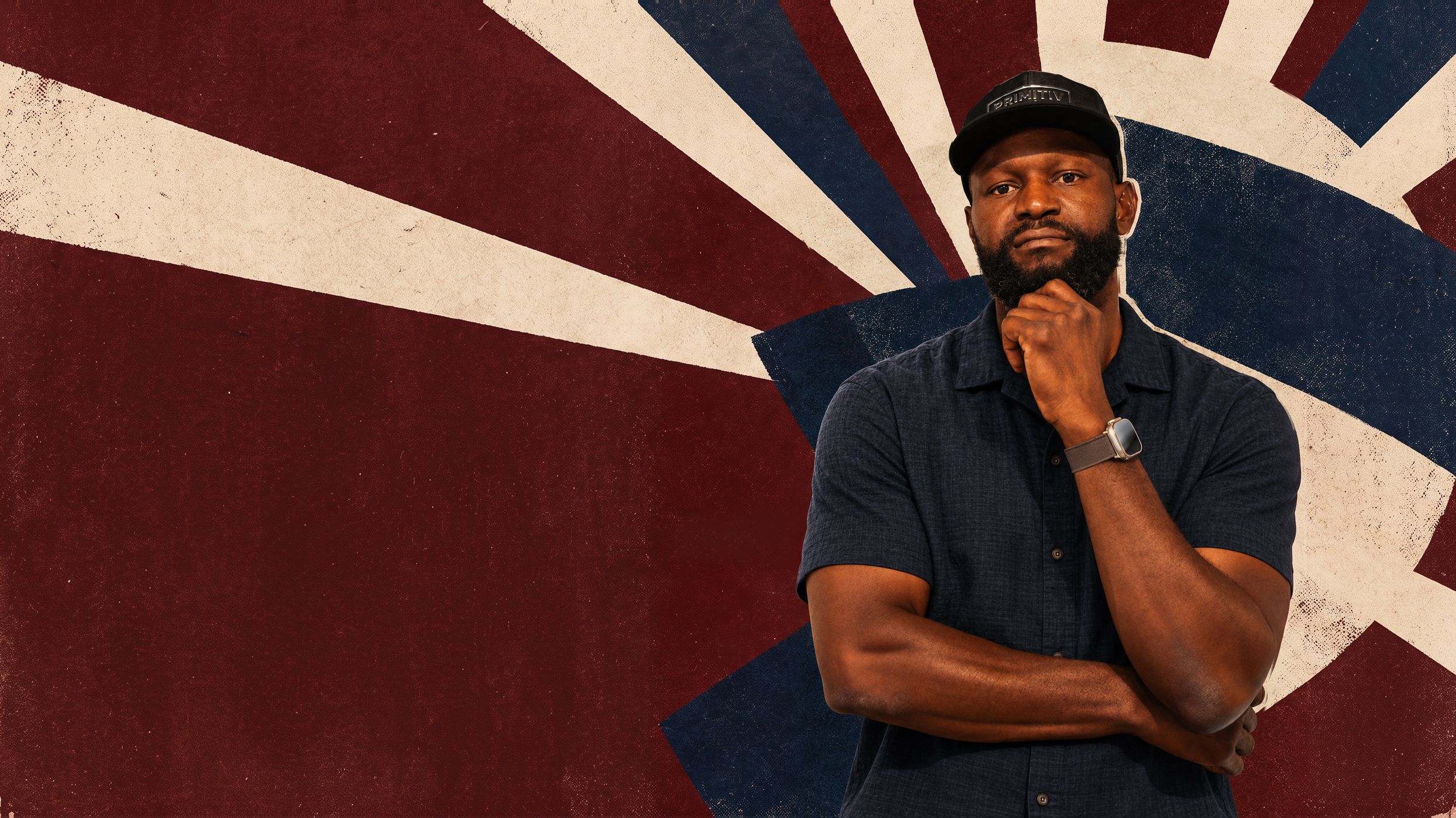 Gosder in a navy shirt and cap, hand on his chin, in front of an oxblood and navy sunburst